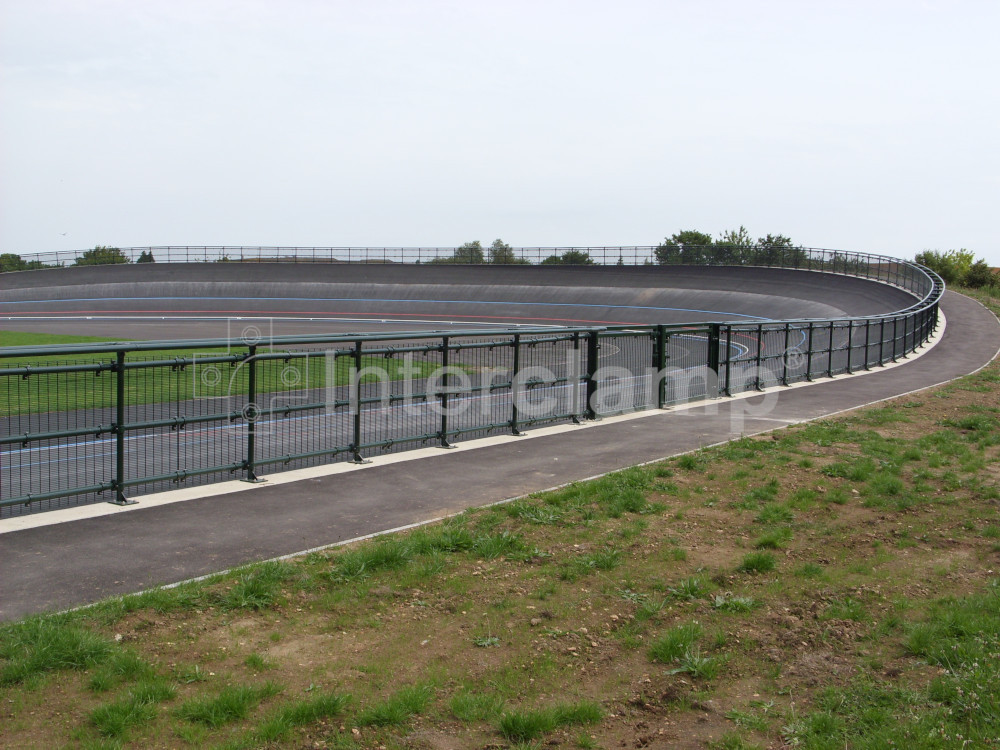 View of a velodrome with a dark green safety barrier made from Interclamp tube clamp DDA fittings, ensuring cyclist safety during high-speed races.